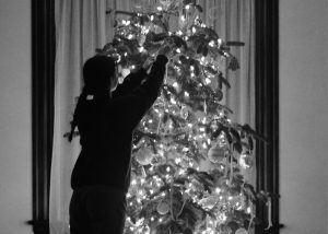 Student decorating a Christmas tree.