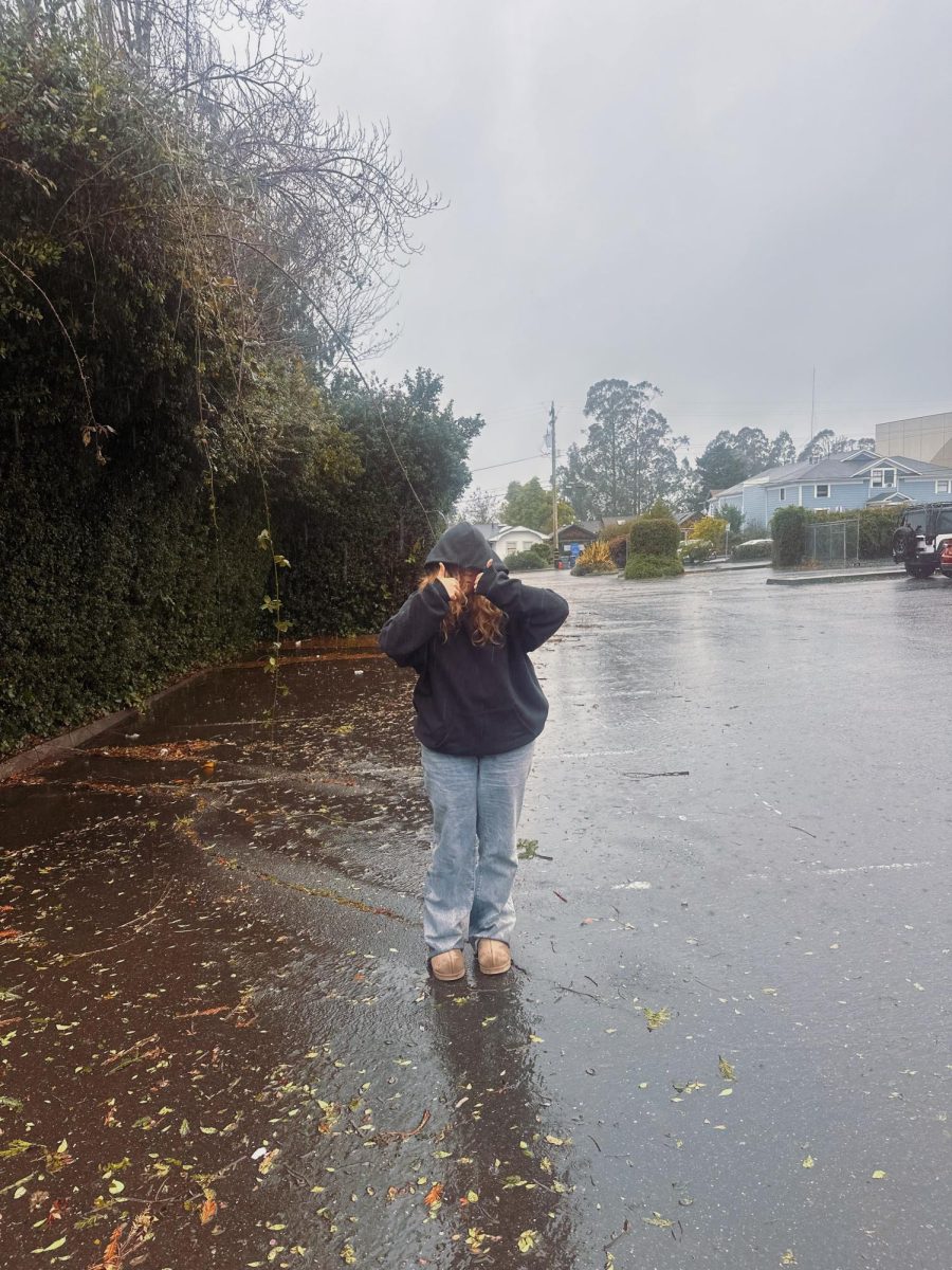 Katelynn Briggs standing outside in the rain. 