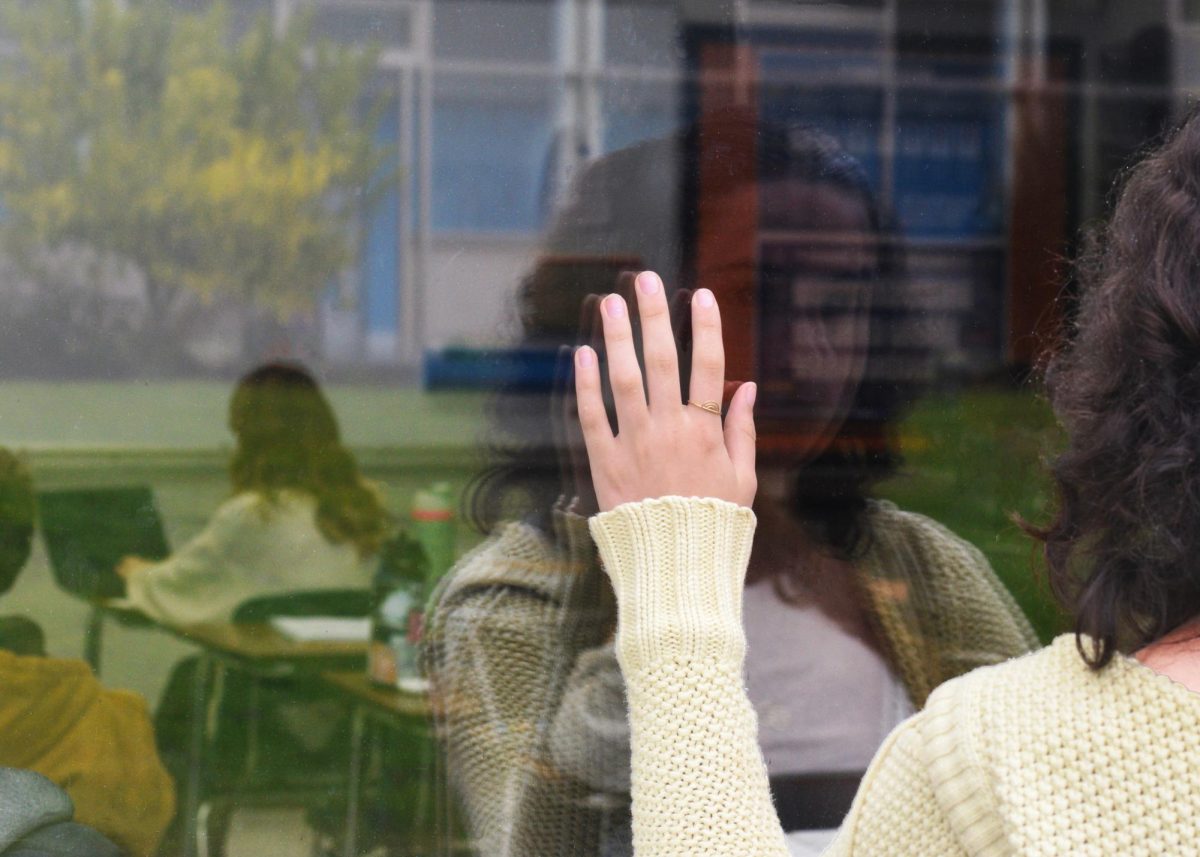 Senior Malea Melendrez looking into a classroom from outside. 