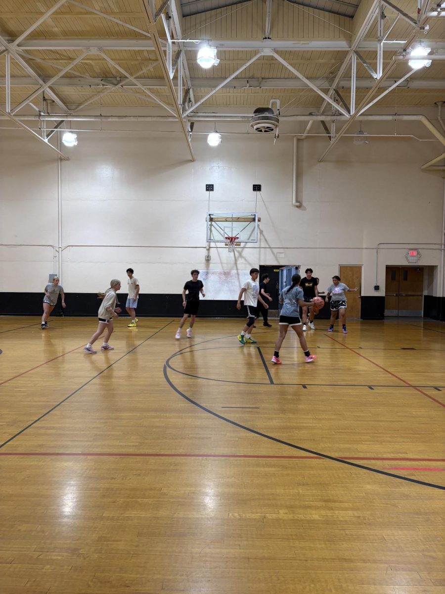 Women's & Men's basketball players scrimmaging a game against each other.