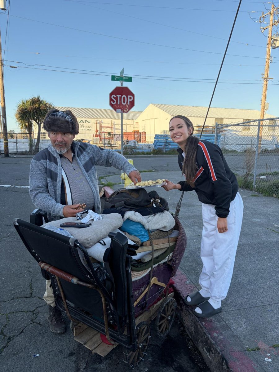Iris Quinlan giving a houseless local, named Steve, chocolates for the Christmas season
