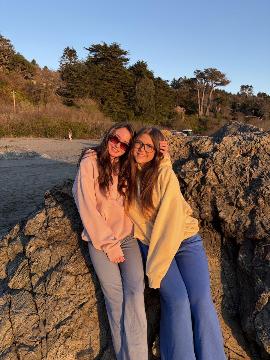 Two students posing at the beach.