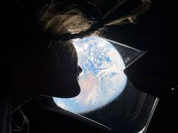 Christina Koch looking at Earth from the Orion spacecraft.